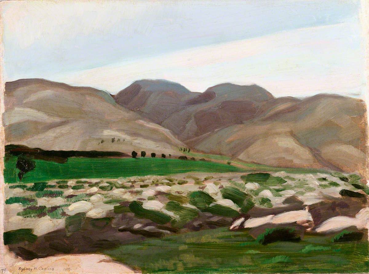 A small oil landscape painting of rolling brown and grey hills under a pale sky, seen across a green cultivated valley floor. In the foreground a dry, stony watercourse cuts through scrubby grass and pale boulders; a line of dark trees marks the far edge of the green field before the bare hills rise behind it.