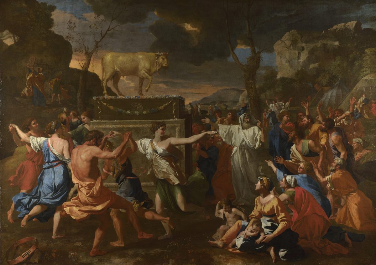 A large classical oil painting. In the left third, a ring of barefoot figures in loose, brightly colored robes — blue, salmon, dark green — dance hand in hand before a tall wooden altar decorated with garlands, on top of which stands a small golden bull calf. A gold ring lies discarded on the ground in the near foreground. In the right two-thirds, a dense crowd of men, women, and children in red, orange, and blue robes gesture with raised arms toward the dancers and the calf; a group of women with small children sits in the lower right corner. Far in the upper left background, tiny and easy to overlook against the rocky hillside, a robed figure holds two flat tablet-shaped objects aloft. The sky above is heavy with dark storm clouds, broken by a narrow band of warm gold light along the horizon.