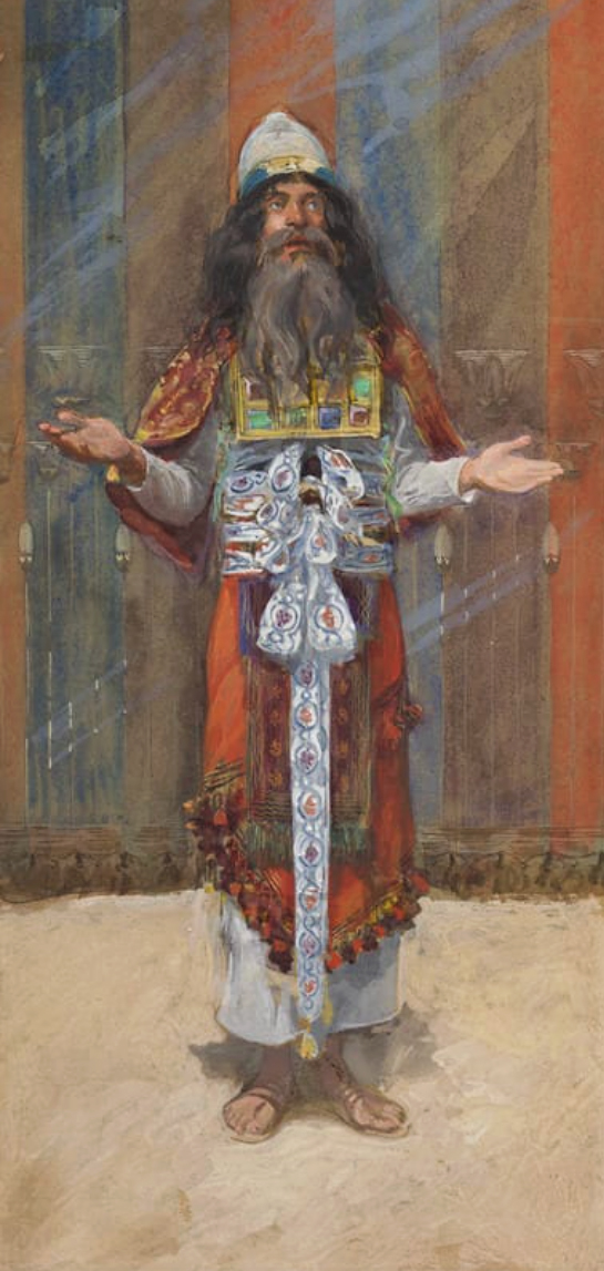 A watercolor study of the high priest in his full vestments, arms raised in a gesture of blessing. He wears a white turban, an orange-and-red striped robe with a fringed, tasseled hem, and a golden breastplate set with rows of colored gems visible on his chest. A long, richly patterned blue-and-white band hangs down the front of his waist to his ankles. He stands barefoot in sandals against a striped curtain backdrop.