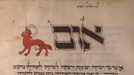 A detail from a medieval parchment manuscript. At the left stands a bright vermilion-red cow in profile, drawn in a flat outline style with curved horns, a dark eye and an oddly long tail. To its right, filling most of the panel, are large ornamented Hebrew letters outlined in ink and filled with dark wash, with small decorative flourishes at their tips. Lines of smaller Hebrew script run above, below and to the right, and the parchment is stained and worn at the edges.