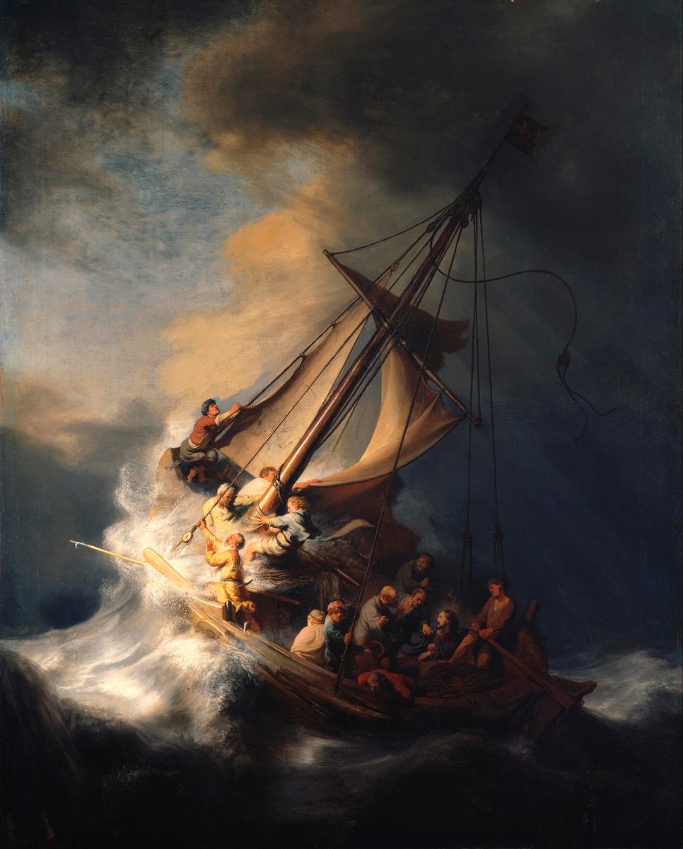A dramatic oil painting of a small fishing boat tilted almost vertically on a huge breaking wave, its sail torn and straining, dark storm clouds filling most of the sky above a single break of pale light at the upper left. At the bow, a man kneels in the rigging hauling on a line; below him, several men strain against ropes and the mast. In the crowded stern, a cluster of men huddle together, one bent forward as if sick, others gripping the boat's sides or looking toward an unseen calm figure among them. At the far right edge, a man in a cap holds a rope and looks directly out of the painting.