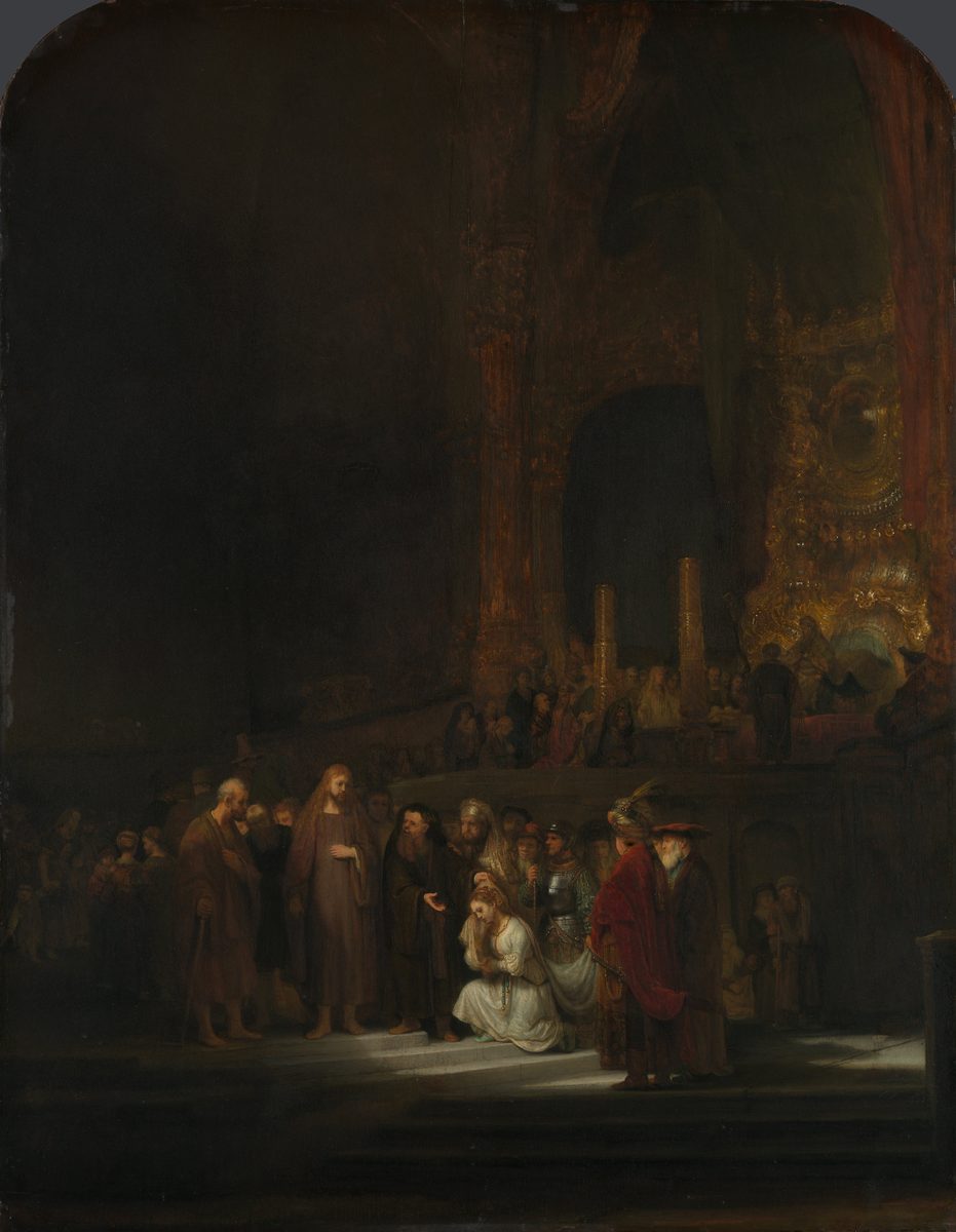 A small, brightly lit woman in a white and gold gown kneels on temple steps at the center of an otherwise vast, shadowy interior. To her left, Christ stands in a pale robe, one hand raised, lit by the same shaft of light. A crowd of richly and variously dressed accusers and onlookers, including a man in armor and another in a red robe and turban, presses close around her. Behind them all, soaring into near-total darkness, rises an immense, gilded temple interior with towering columns, a raised dais, and a distant crowd of tiny figures lost in the gloom above.