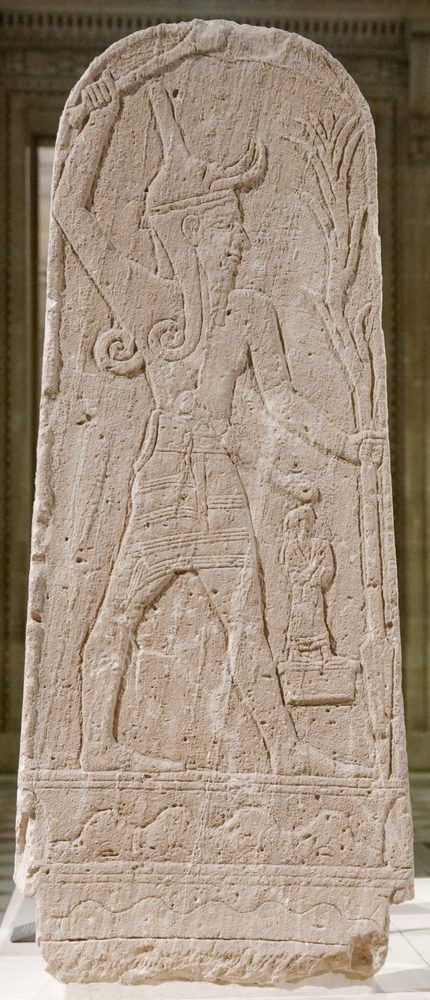Limestone stele of Baal holding a raised mace and a downward-pointing spear, from Ugarit, in the Louvre