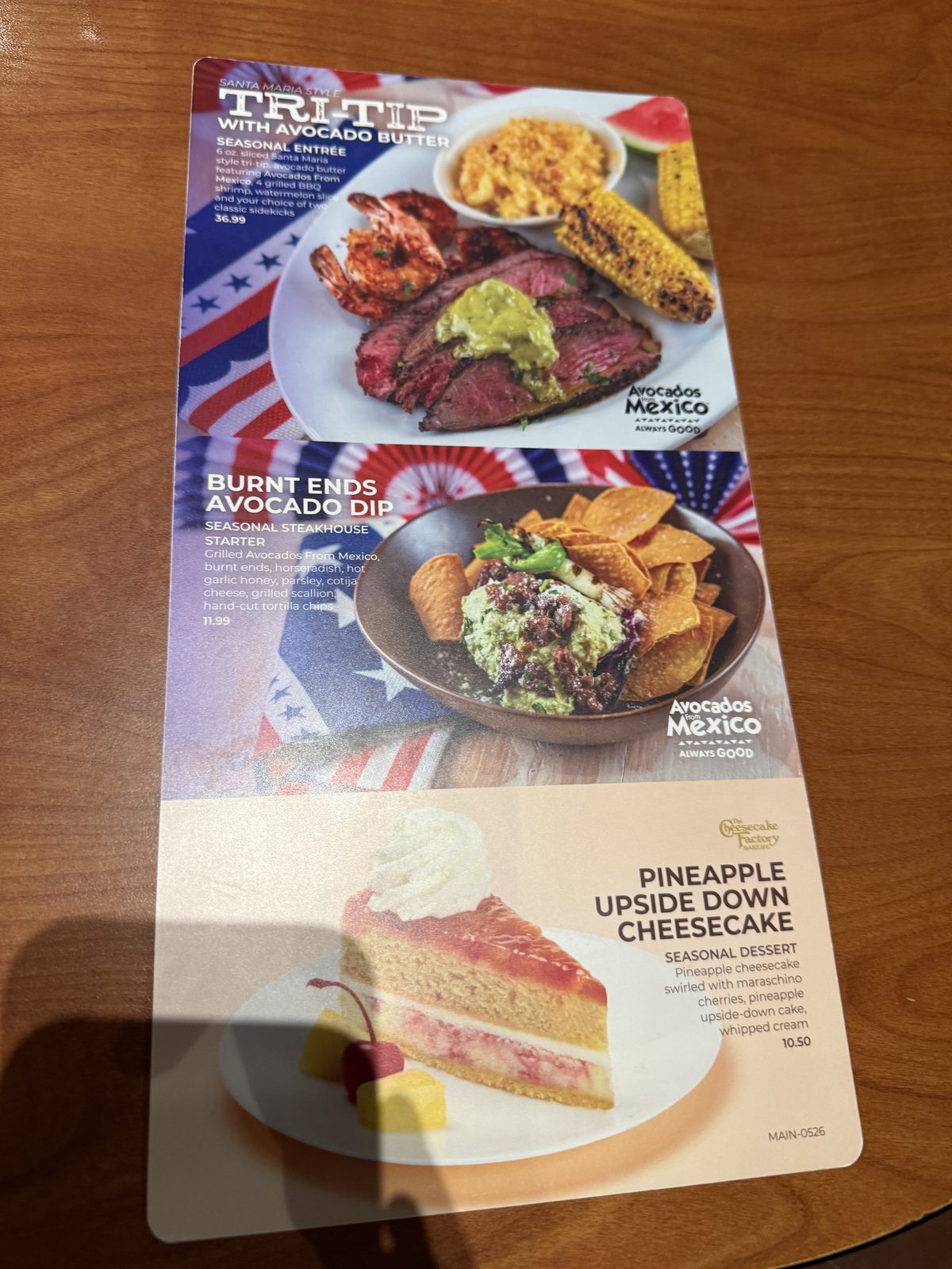 A seasonal specials insert listing Santa Maria Style Tri-Tip with avocado butter and grilled shrimp for $36.99, a Burnt Ends Avocado Dip appetizer with tortilla chips for $11.99, and a Cheesecake Factory Bakery Pineapple Upside Down Cheesecake for $10.50, each with its own photo