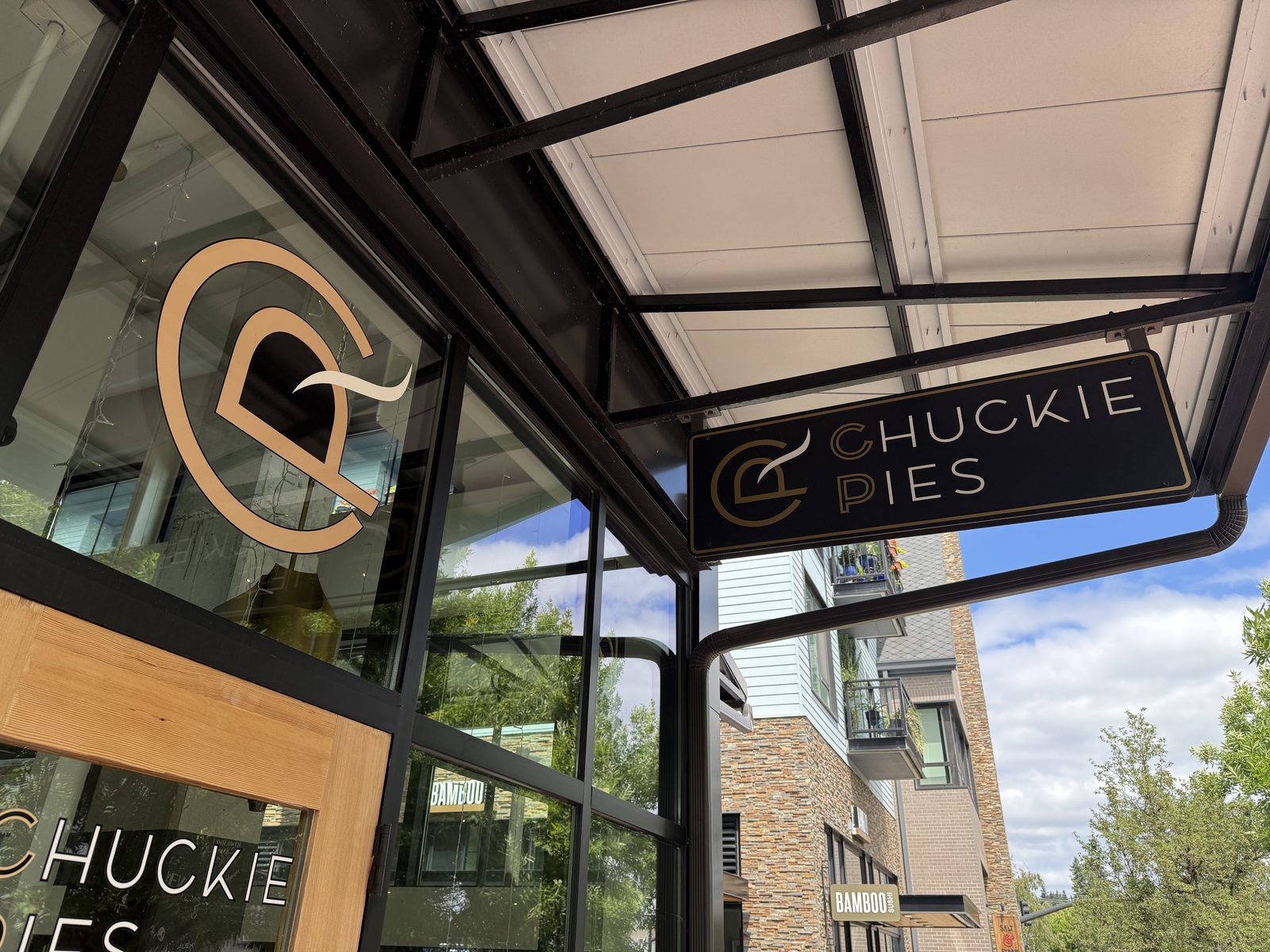 The Chuckie Pies hanging sign, a gold C-and-fork mark beside the name in gold letters on a black background