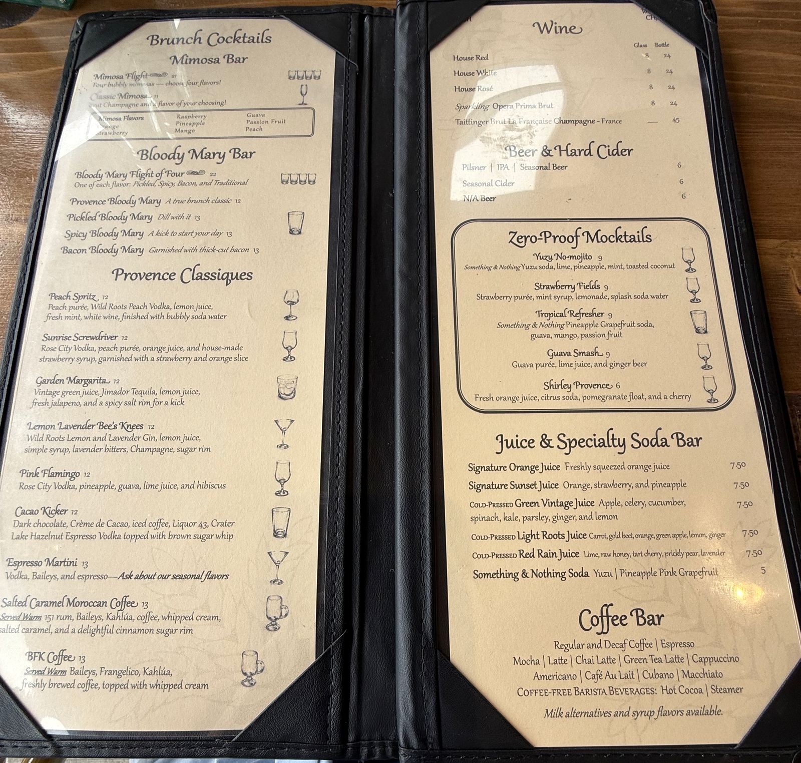 The La Provence drinks menu, left page listing brunch cocktails including a mimosa flight of four and a bloody mary flight of four, right page listing wine, beer, zero-proof mocktails including the Shirley Provence, a juice and specialty soda bar and a coffee bar