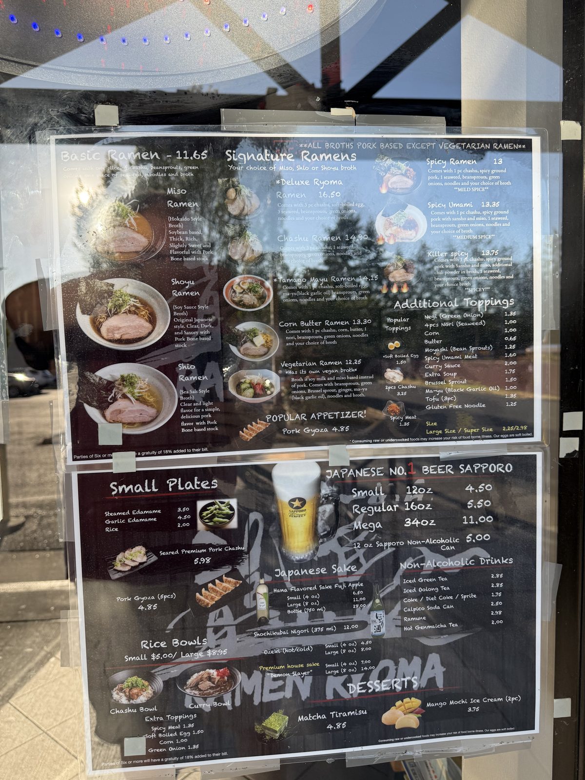 The two menu boards in the window: ramen and signature bowls on one, small plates, beer, sake and desserts on the other
