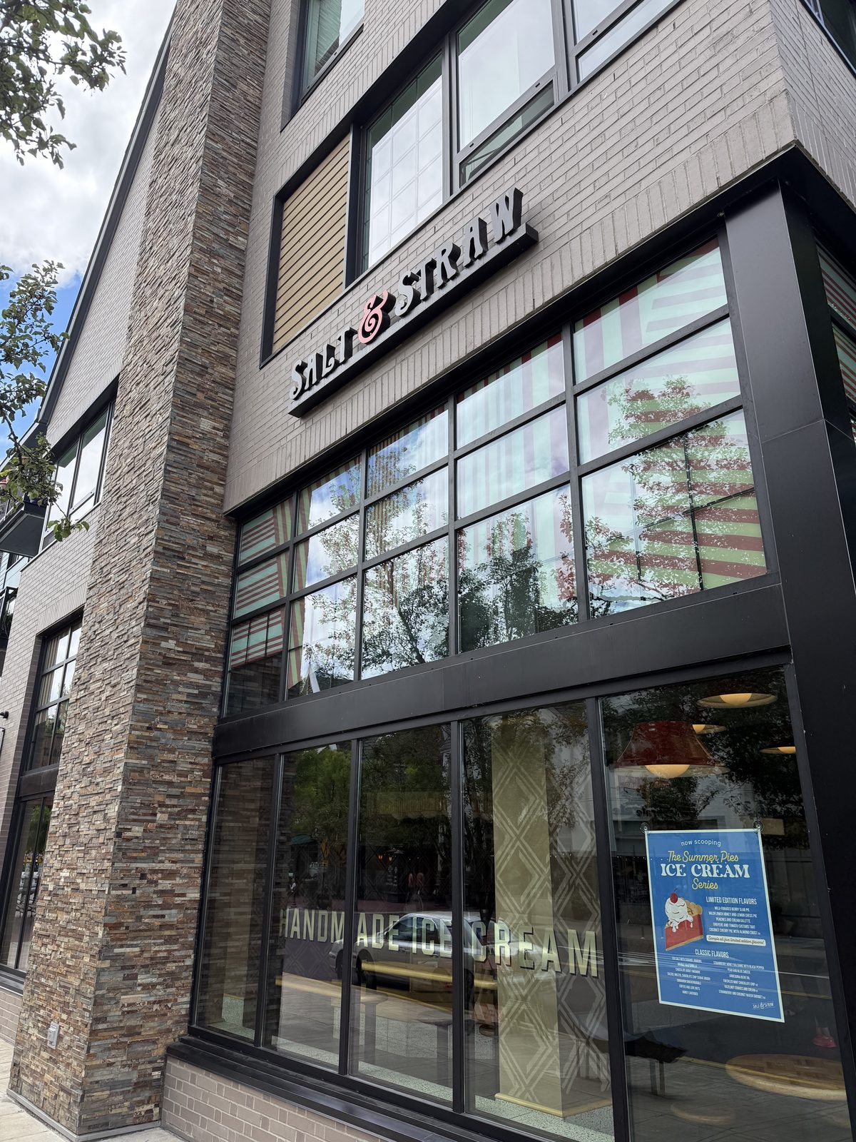 The Salt & Straw sign in wood-cut lettering with a red ampersand, mounted on a stone-tiled storefront corner
