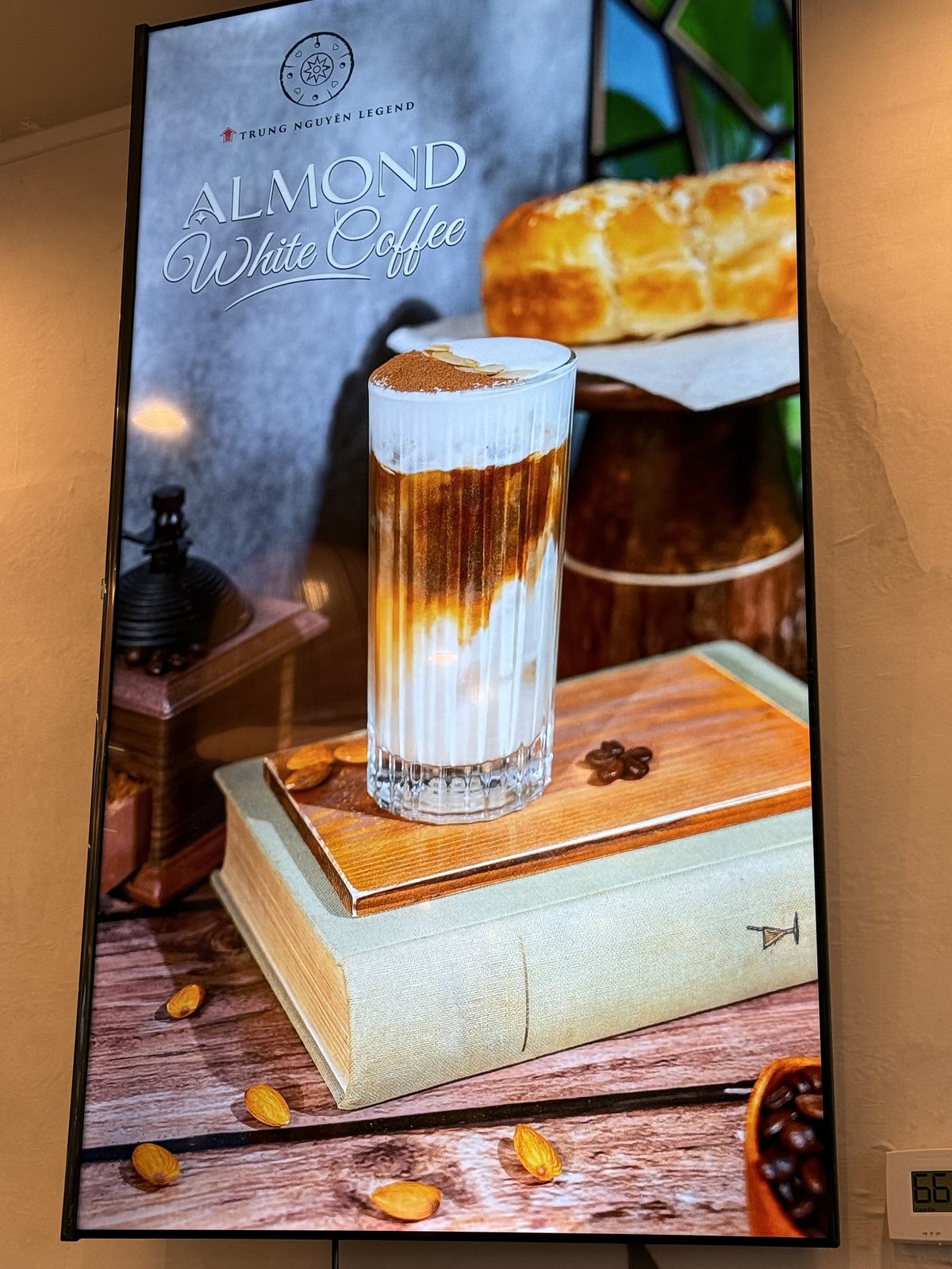 Digital menu board for Almond White Coffee, a layered iced coffee drink on a book, with almonds scattered around