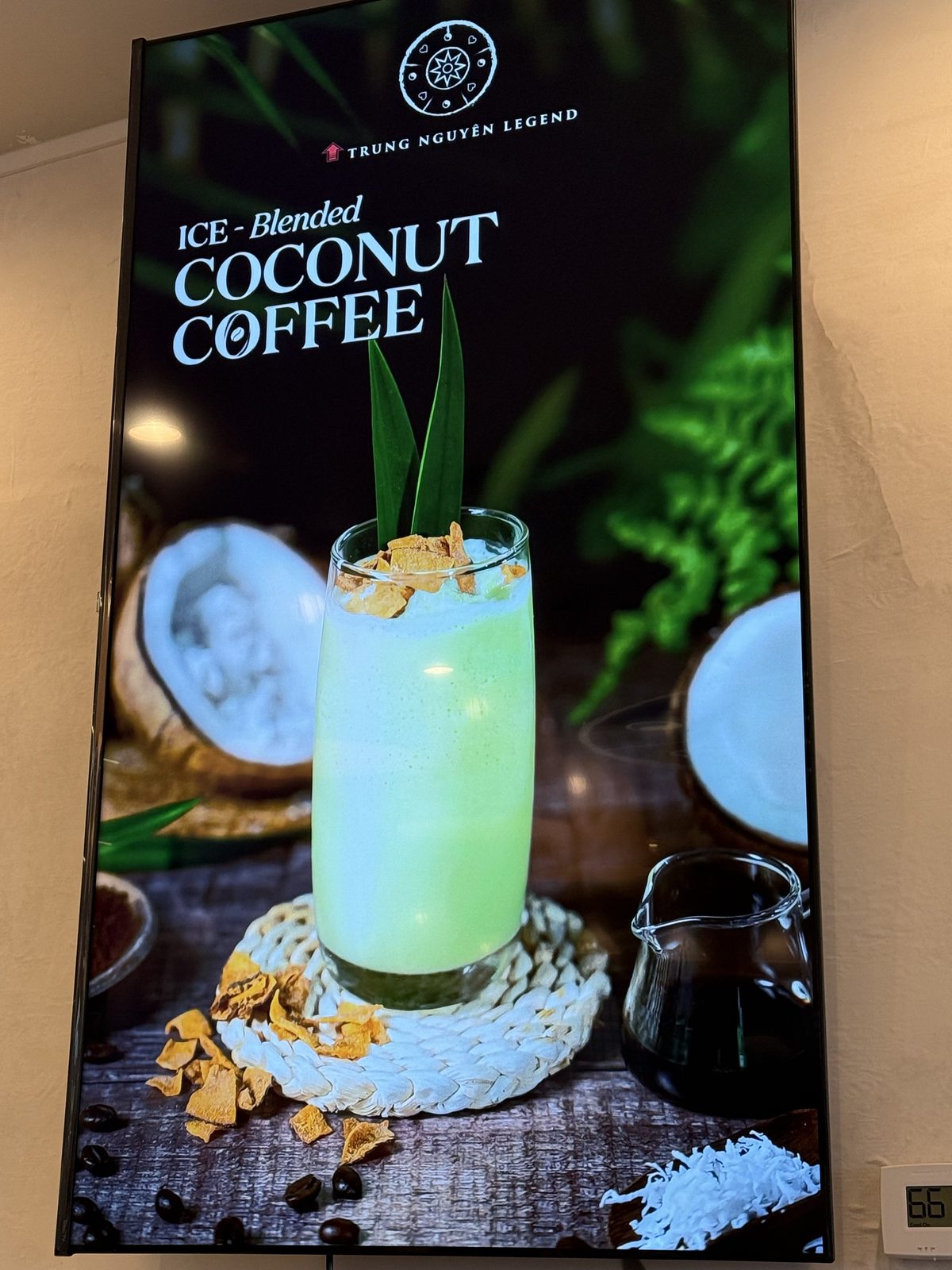 Digital menu board for Ice-Blended Coconut Coffee, a pale green blended drink garnished with pandan leaves next to a split coconut