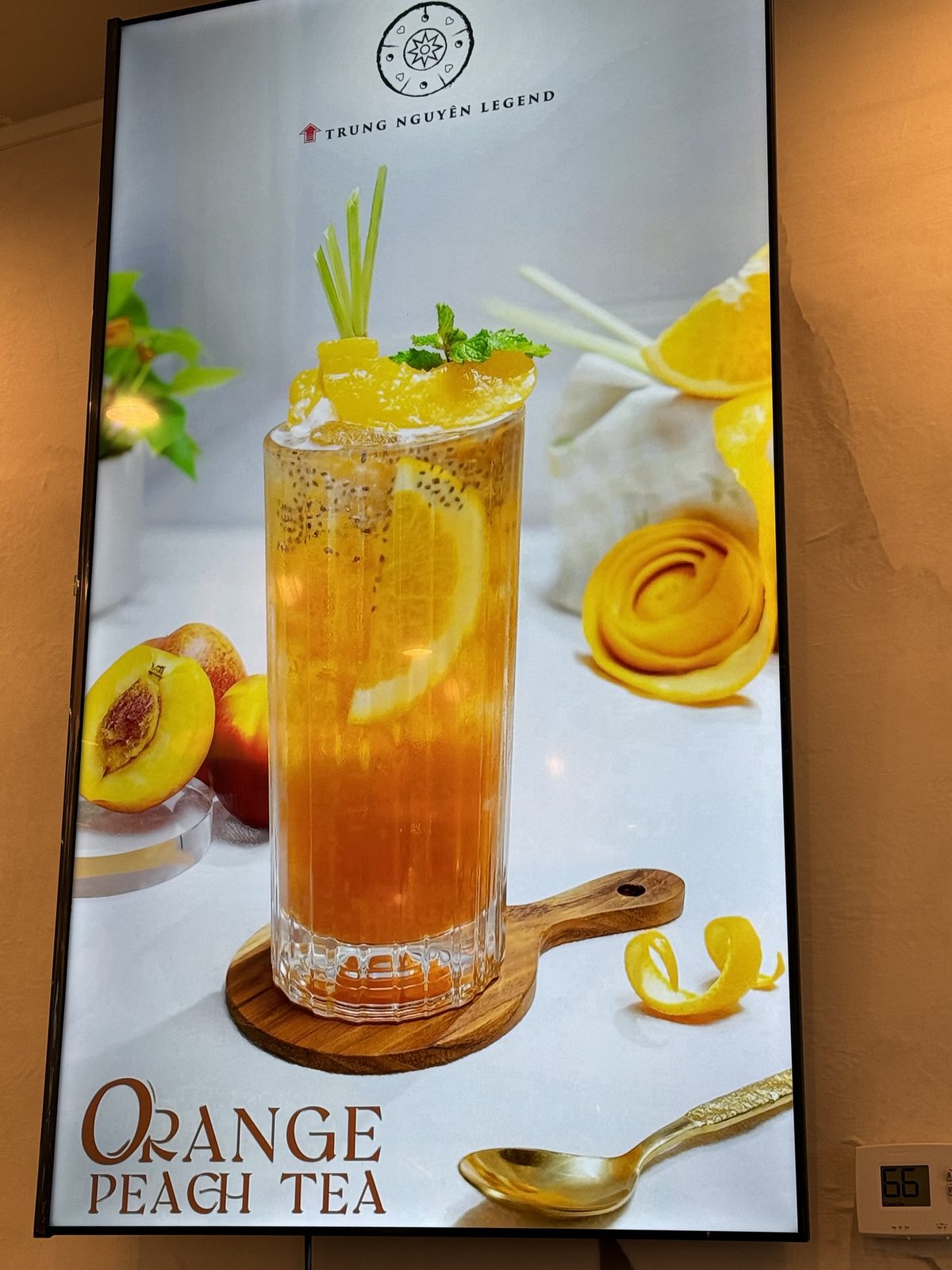 Digital menu board for Orange Peach Tea, a tall iced tea garnished with orange and peach slices and mint