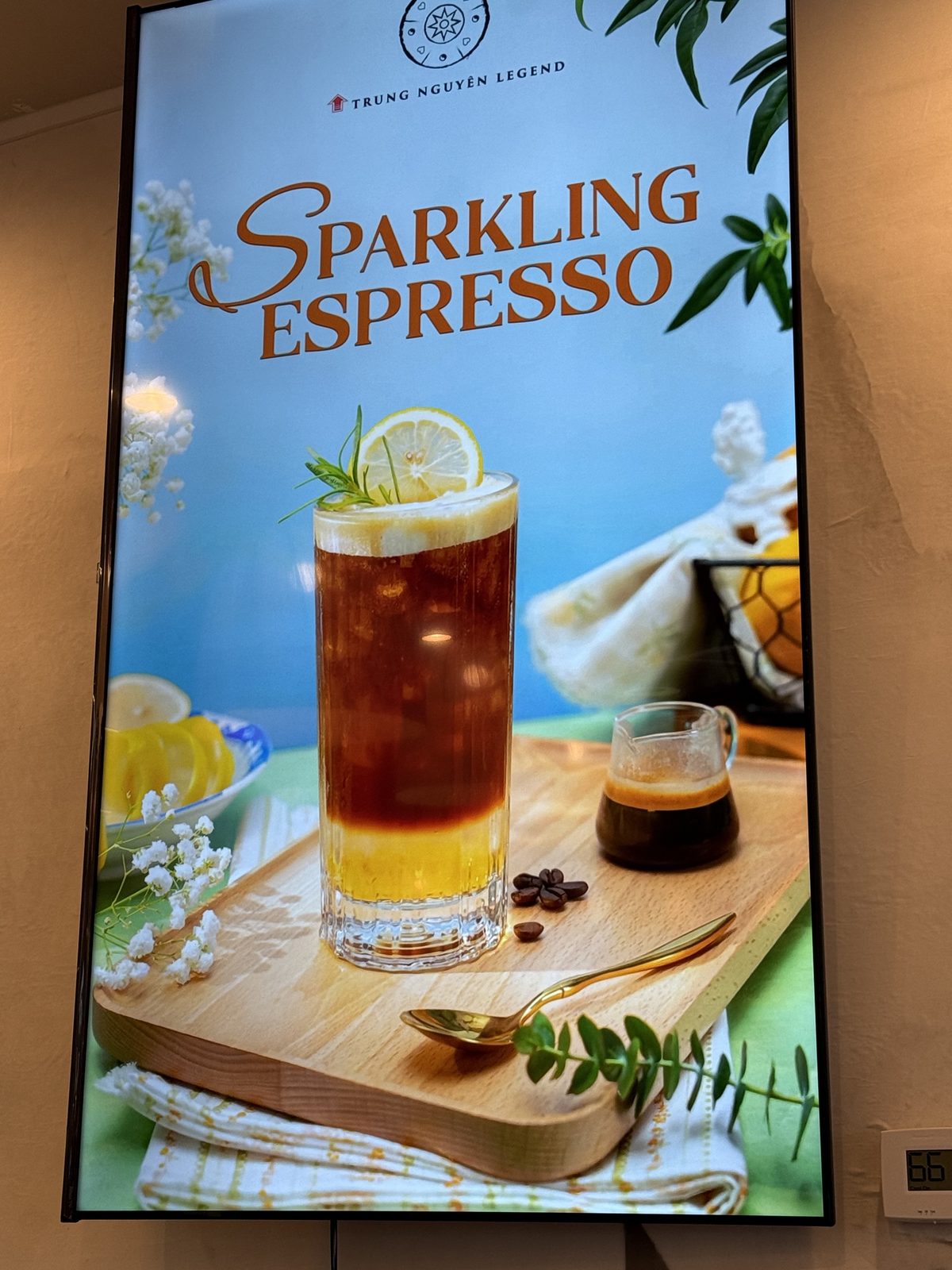 Digital menu board for Sparkling Espresso, a tall glass of sparkling coffee garnished with a lemon wheel and rosemary