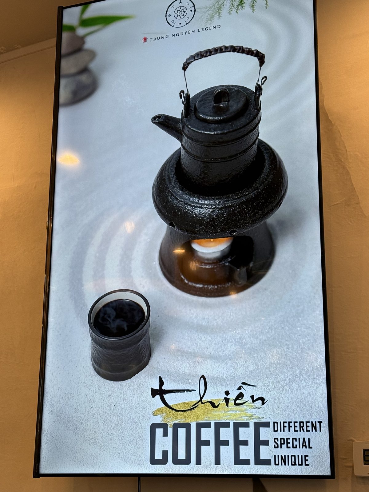 Digital menu board styled as a Zen rock garden with a small cast-iron kettle and cup, labeled Thien Coffee — different, special, unique